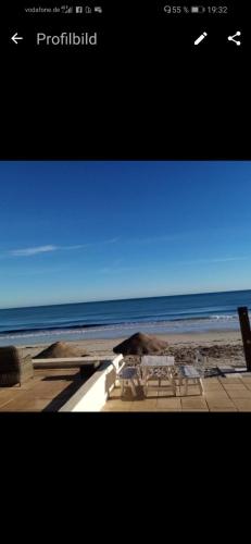納布勒的住宿－H. Younes，海滩上设有桌椅,大海上设有沙滩