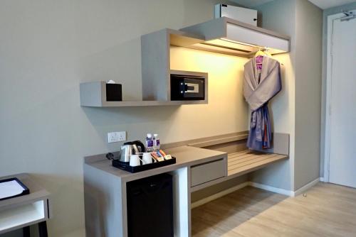 een kamer met een keuken met een aanrecht en een magnetron bij Qliq Damansara Hotel in Petaling Jaya