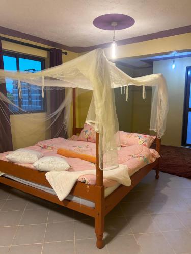 a bedroom with a bed with a canopy at 020-22 Airbnbs in Thika