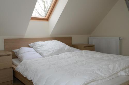 a bedroom with a bed with white sheets and a window at Haus Ost in Mechelsdorf