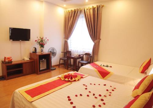 um quarto de hotel com duas camas com corações em Khách sạn Bảo Sơn 1 em Lao Cai