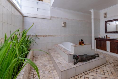 a bathroom with a tub and a toilet and a sink at Villa Coco Bali in Seminyak