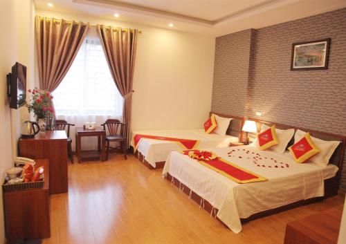 a hotel room with two beds and a window at Khách sạn Bảo Sơn 1 in Lao Cai