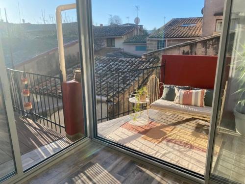 une véranda avec un banc sur un balcon dans l'établissement MAISON PLEIN SUD SUR LES TOITS au 2 terrasses, à Montagnac