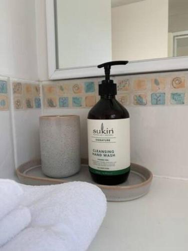a bottle of soap sitting on a shelf in a bathroom at Beauchamp Beauty - Loft apartment in Albany