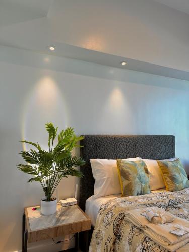 Un dormitorio con una cama y una mesa con una planta en 38 Park Avenue Condominiums, en Cebú
