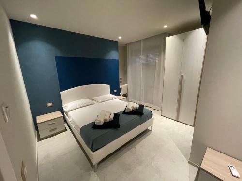 a bedroom with a white bed and a blue wall at Nonna Mina B&B in Rapagnano