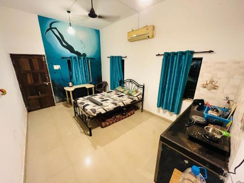 a bedroom with a bed in a room with blue walls at Coral Reef - NestinGoa Homestays in Arambol