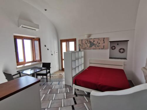 a bedroom with a red bed and a table at Il Nido Del Falco - Art house with terrace and sea view in Furore
