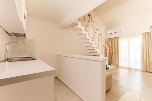 a white staircase in a kitchen with a sink at Mystery Suites and Apartments in Nei Poroi