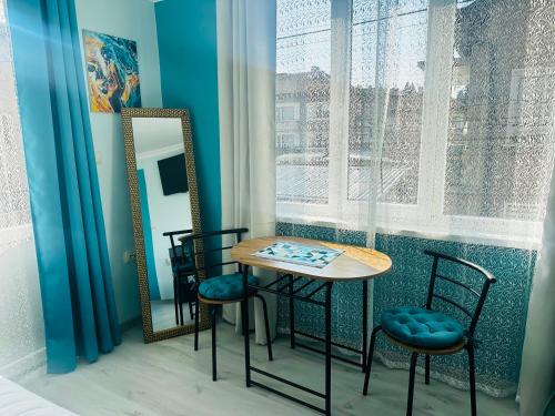 a table and chairs in a room with a mirror at VELI HOUSE VELINGRAD/ ВелиХаус Къща за гости Велинград in Velingrad