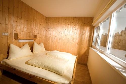 a small bedroom with a bed with a window at Hütte Präbichl in Vordernberg
