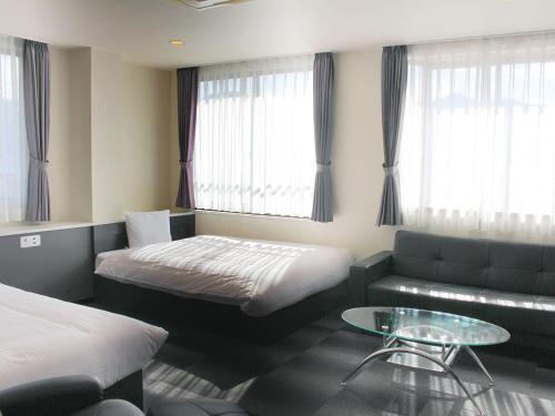 Habitación de hotel con cama y sofá en Hotel Viora, en Owase