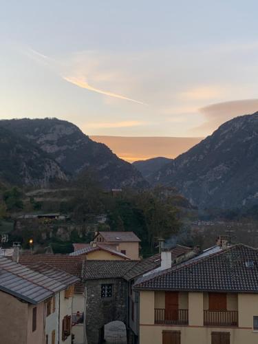 a group of buildings with mountains in the background at Maison Jehan-Séré in Tarascon-sur-Ariège