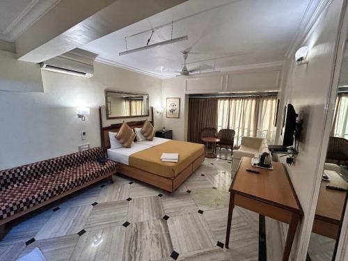 a hotel room with a bed and a desk at Royal Park Hotel Dockyard in Mumbai