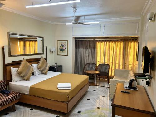 a hotel room with a bed and a living room at Royal Park Hotel Dockyard in Mumbai