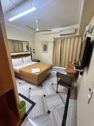 a bedroom with a bed and a tv in a room at Royal Park Hotel Dockyard in Mumbai