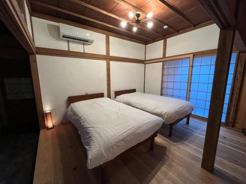 duas camas num quarto com duas janelas em CalmbaseRIVER - Vacation STAY 22009v em Numazu