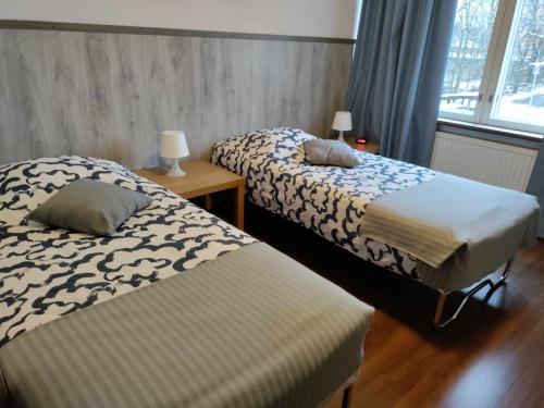 Un dormitorio con dos camas y una ventana. en Hotel Ackas, en Toijala