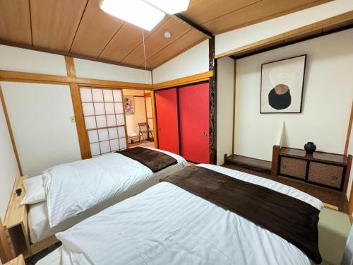 伊豆的住宿－CalmbaseGARAGE - Vacation STAY 50325v，红色门的客房内的两张床