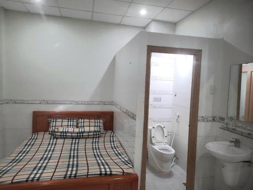 een slaapkamer met een bed, een toilet en een wastafel bij 18 Homestay Star's in Can Tho