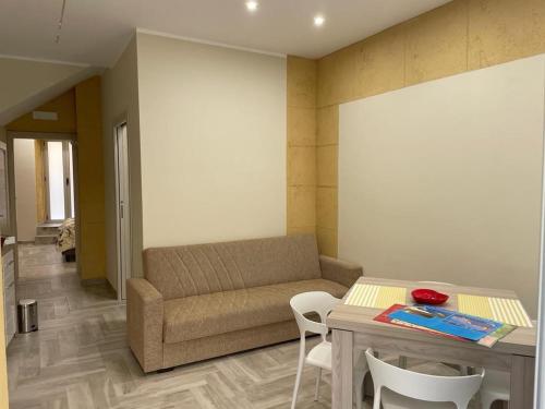 Una sala de estar con un sofá, una mesa y sillas. en SIKELIA LUXURY ROOMS, en Agrigento