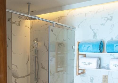 a bathroom with a shower with a glass door at Stone Hotels Dhiffushi in Dhiffushi