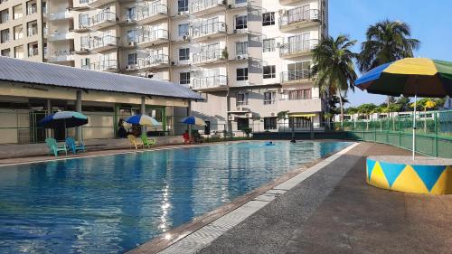 une piscine devant un grand bâtiment dans l'établissement The EH's Homestay Marina View Villa PortDickson, à Port Dickson
