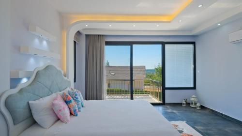 um quarto com uma cama grande e uma janela grande em Villa Lotus Yeşilüzümlü em Fethiye