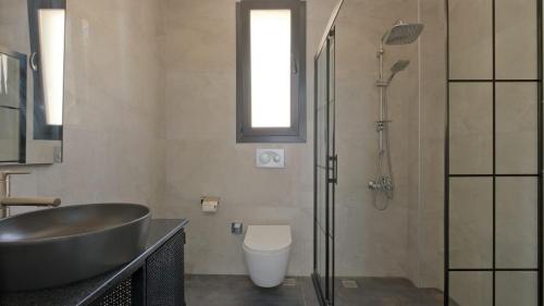 uma casa de banho com um lavatório, um chuveiro e um WC. em Villa Lotus Yeşilüzümlü em Fethiye