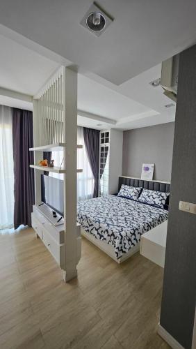 a bedroom with a bed and a tv in it at The Patio BangsaenF6 R71 in Ban Bang Saen (1)