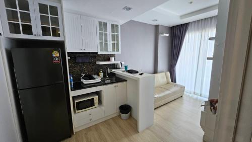 a kitchen with a black refrigerator and a microwave at The Patio BangsaenF6 R71 in Ban Bang Saen (1)