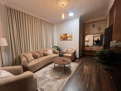 a living room with a couch and a table at Ban Luxury Apartments in Al Khobar
