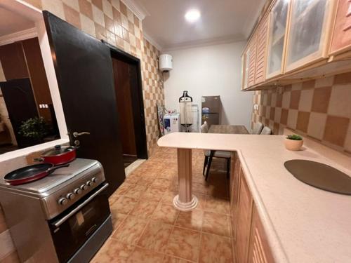 a kitchen with a stove and a counter top at Ban Luxury Apartments in Al Khobar