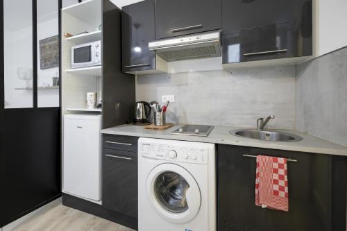 a kitchen with a washing machine and a sink at Le petit MIAMI in Thionville