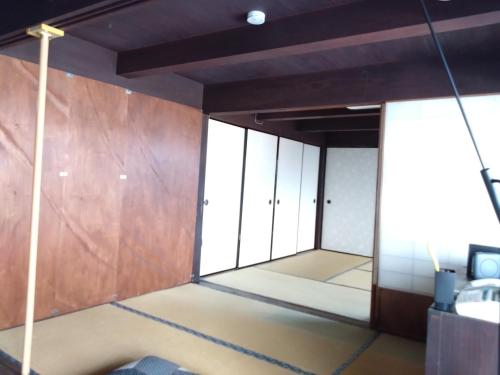 a room with sliding doors in a room at ゲストハウス　シン熊野 in Tanabe