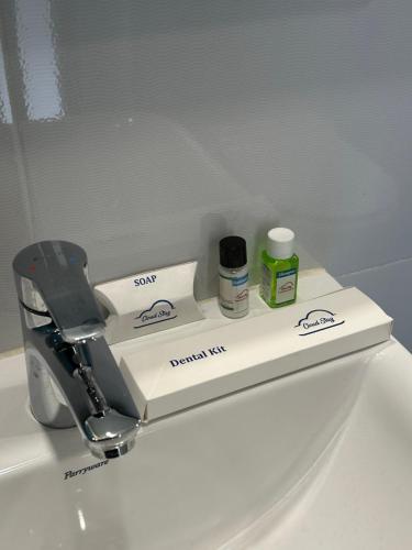 a bathroom sink with a faucet and toiletries on it at Cloud Stay in Guwahati