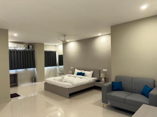 a bedroom with a bed and a couch and a chair at Cloud Stay in Guwahati