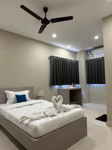 1 dormitorio con 1 cama grande y ventilador de techo en Cloud Stay, en Guwahati