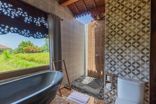 a bath tub in a bathroom with a window at Billys Ayodya Villa in Perean