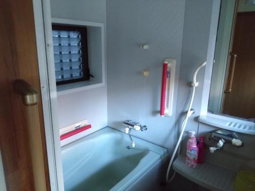 y baño con lavabo y bañera. en ゲストハウス　シン熊野, en Tanabe