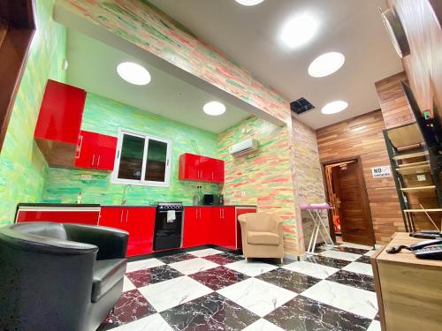eine Küche mit roten Schränken und einem karierten Boden in der Unterkunft Bays Boutique Apartment in Accra