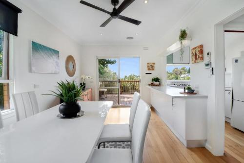 a kitchen and dining room with a white table and chairs at Scenic Serenity Large Family Home in Geelong in Geelong