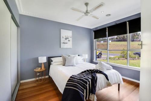a bedroom with a large bed and a window at Scenic Serenity Large Family Home in Geelong in Geelong
