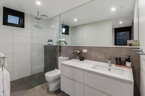 La salle de bains blanche est pourvue de toilettes et d'un lavabo. dans l'établissement Retreat on Bellerine I Corporate or Getaway, à Geelong