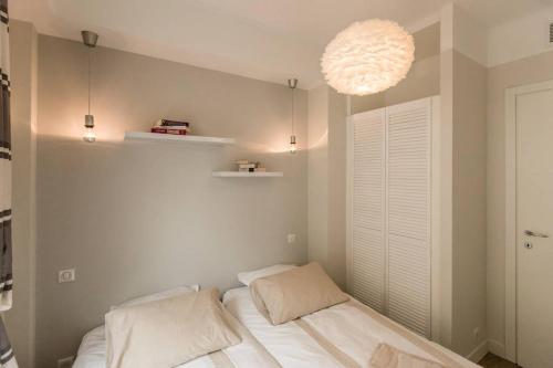 une chambre avec un lit avec deux oreillers dessus dans l'établissement Le Massenet France, à Nice