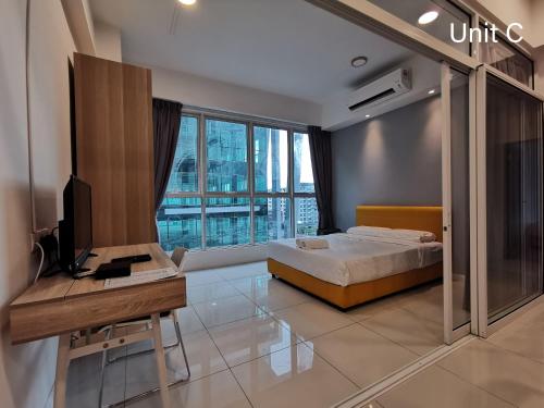a bedroom with a bed and a desk with a computer at JC Suites @ Sutera Avenue in Kota Kinabalu