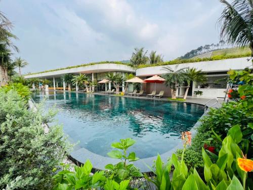 - une piscine dans un complexe avec un bâtiment dans l'établissement ARECA VILLA F316 Venus- Bể bơi nước ấm - Warm water swimming pool, Xông hơi - Sauna, Bi-A, Sup, Karaoke, BBQ, Wifi free, à Thanh Cao