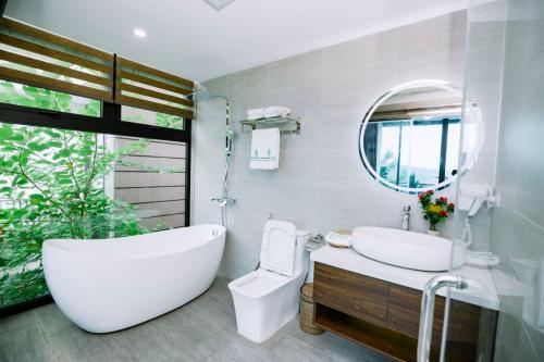 une salle de bain avec une baignoire, des toilettes et un lavabo dans l'établissement ARECA VILLA F316 Venus- Bể bơi nước ấm - Warm water swimming pool, Xông hơi - Sauna, Bi-A, Sup, Karaoke, BBQ, Wifi free, à Thanh Cao