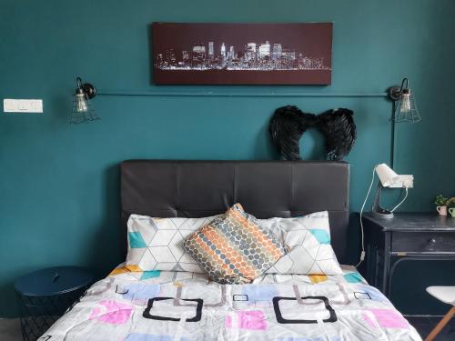 Un dormitorio con una pared azul y una cama en A Comfy & Stylish Studio in Empire Damansara, en Petaling Jaya